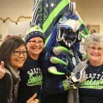 Evan Pappas/Staff Photo                                Jo Takeyama, Janet Kautz and Carol Kautz pose with the Seahawks Rooster, Nick Goins at the Sno-Valley Senior Center 12 Days of Goodness lunch Sept. 21.