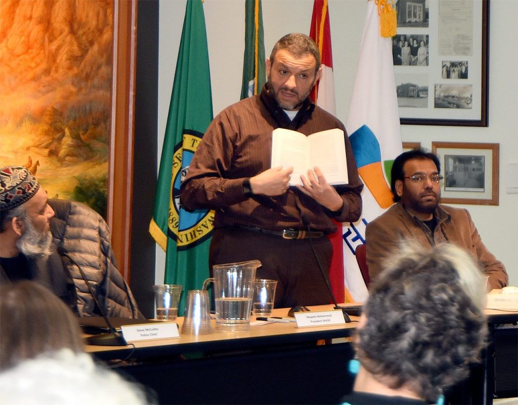 Alaa Badr, an Islamic scholar from Redmond, holds a bilingual Quran as he discusses Islam with some 200 guests at the Snoqualmie Muslim Association open house.                                Carol Ladwig/Staff Photo