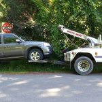 A tow truck hauls off an illegally parked car on Mount Si Road last summer, which became a much more common sight after the DNR got authority from the county sheriff to ticket and tow such trailhead parkers.                                Courtesy Photo