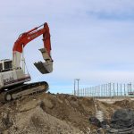 An excavator is driven up a mound of dirt on the site of the future Safeway store and Bartell Drugs complex, on Snoqualmie Parkway and S.E. Center Street. Both stores are targeting openings later this year. (Evan Pappas/Staff Photo)