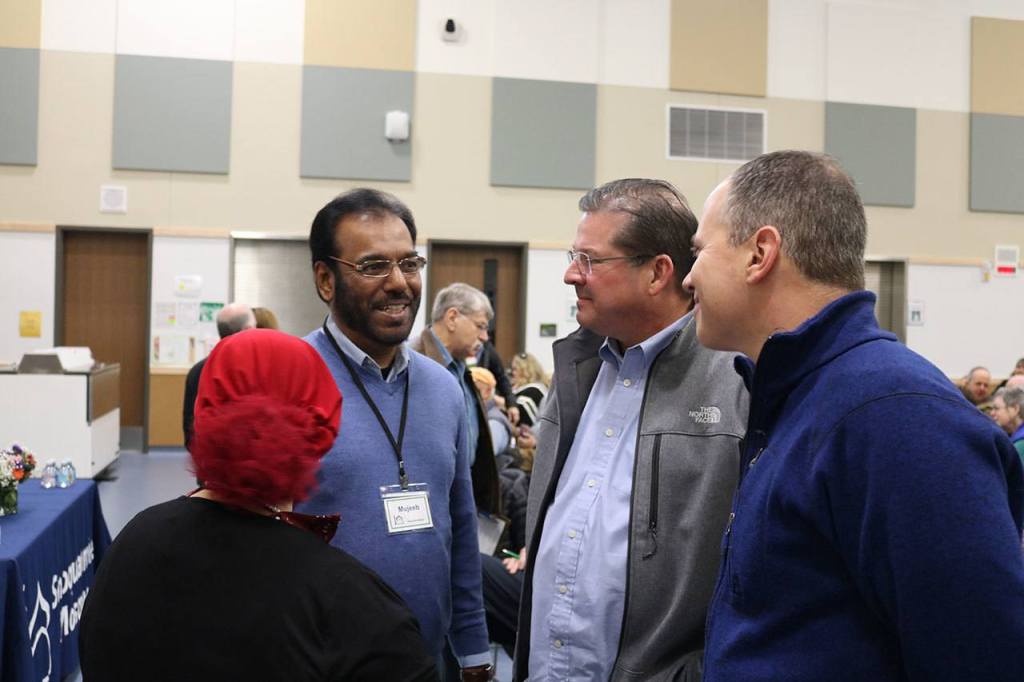 Mujeeb Mohammed speaks with Snoqualmie Valley School District Superintendent Joel Aune and School Board member Tavish MacLean. (Evan Pappas/Staff Photo)
