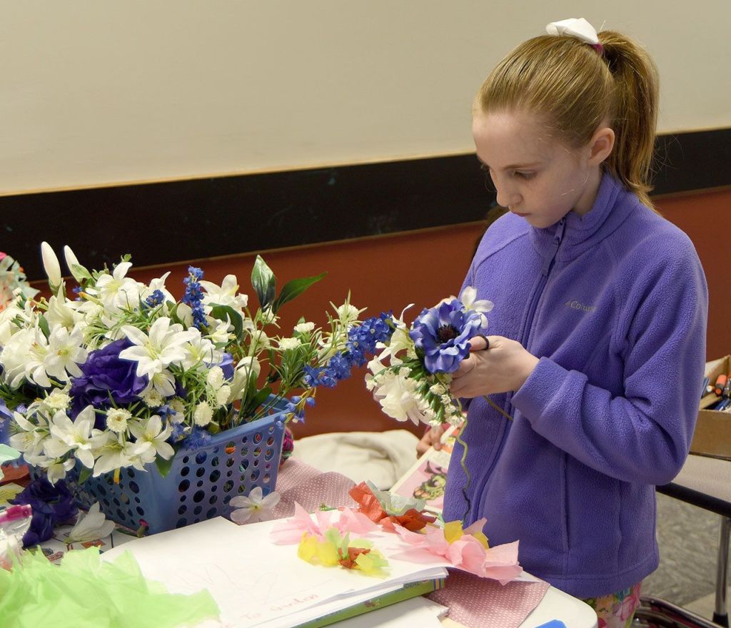 Cassidy Stallings adds to her floral arrangement at the children&rsquo;s crafts table at the Snoqualmie Valley Seed Exchange.                                Carol Ladwig/Staff Photo