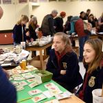Cedarcrest high School FFA members Megan Reid and Madison Bean volunteer at the seed exchange.                                Carol Ladwig/Staff Photo