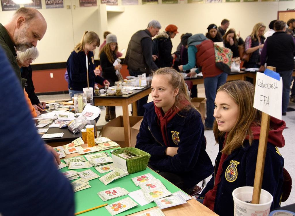 Cedarcrest high School FFA members Megan Reid and Madison Bean volunteer at the seed exchange.                                Carol Ladwig/Staff Photo