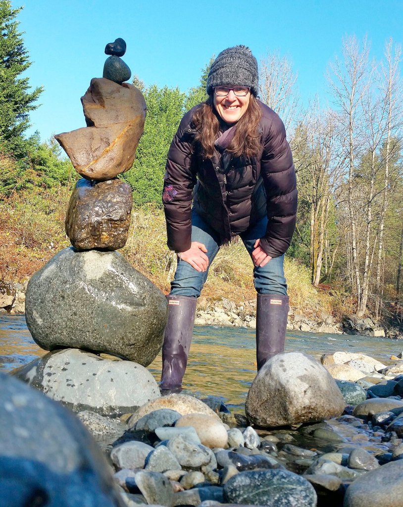 Valley Artist Ellen Rowan stands by a stack of rocks with one of her &ldquo;lovebombs&rdquo; perched on top. (Courtesy Photo)
