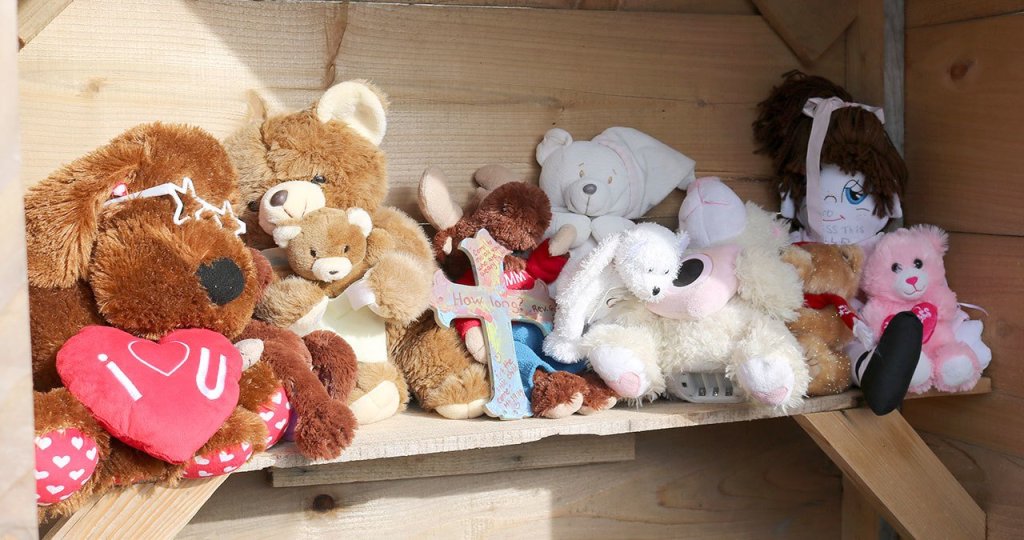 Evan Pappas/Staff Photo                                Stuffed animals and a homemade cross were placed by local residents to honor the memory of the infant found near Kimball Creek in 2014.