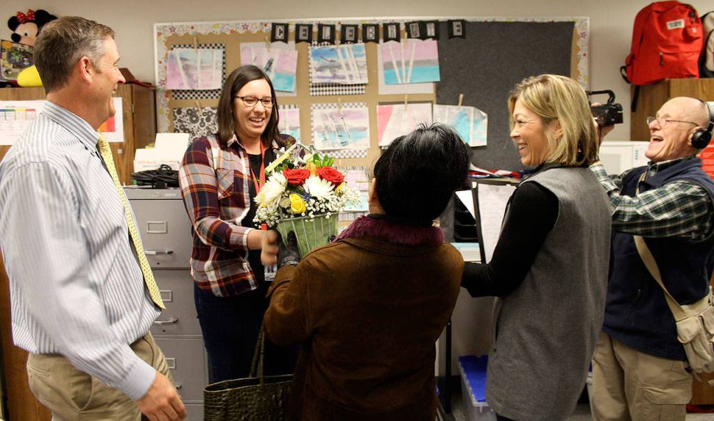 Katelyn Walker, a life skills teacher at Mount Si High School, accepts a basket of flowers from the Snoqualmie Valley Schools Foundation committee, which just announced she was the High School Educator of the Year.