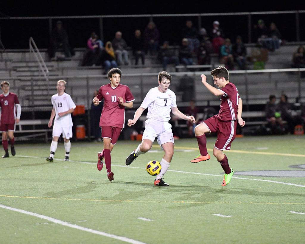 Andy Kirby faces off against two Eastlake players as he gets into position to pass. (Photo courtesy of Calder Productions)
