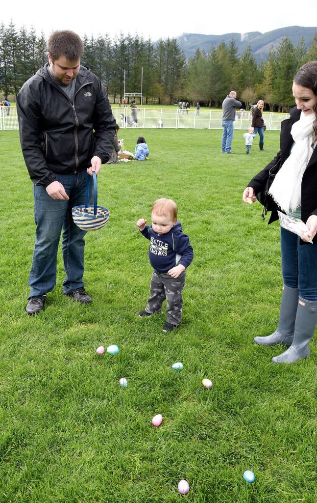 Carter Coleman, 19 months, was more interested in picking up eggs at Snoqualmie&rsquo;s hunt Saturday morning at Centennial Field, than he was in find out what was inside them. His parents, Tim and Angela Coleman obliged by tossing eggs from his basket back onto the grass for him to collect again and again. Carol Ladwig/Staff Photo
