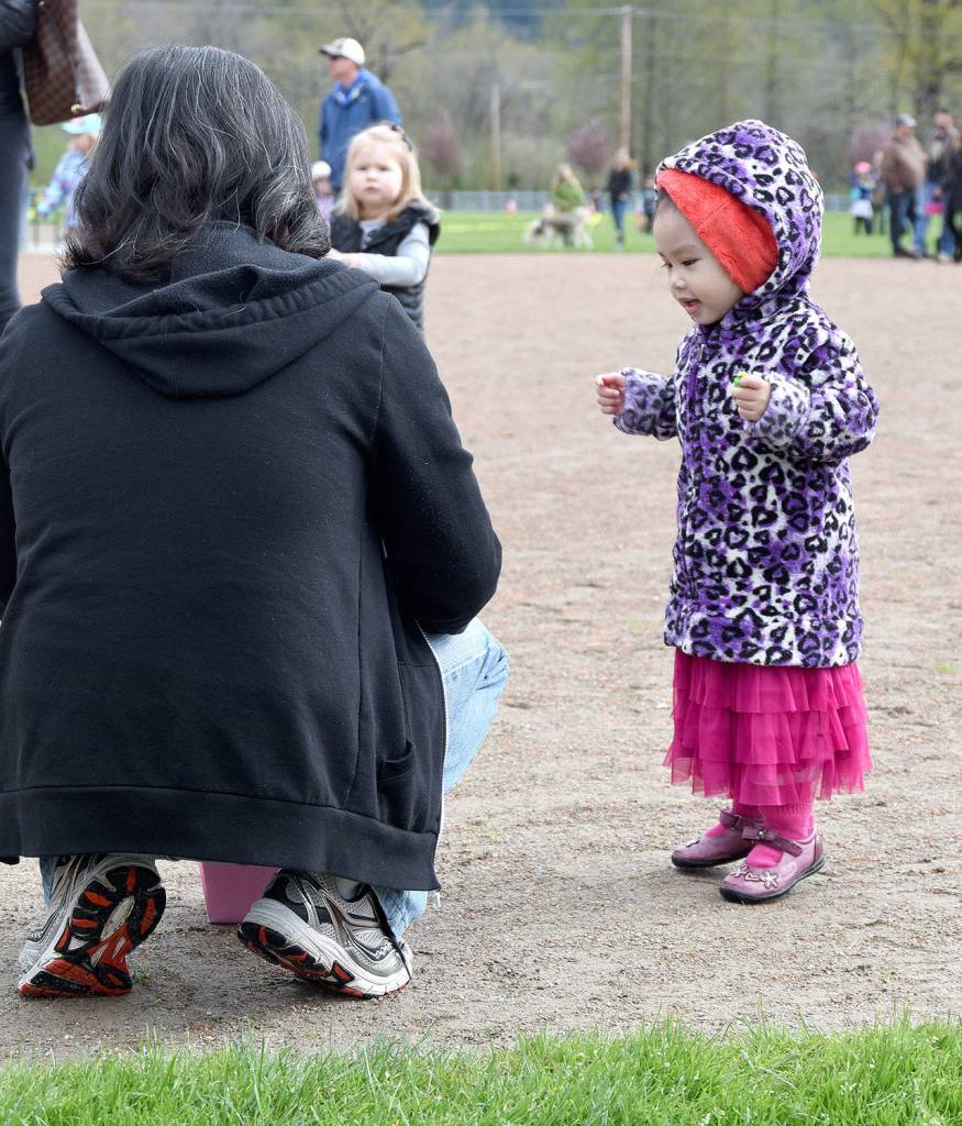 Sophie Nguyen, age 2, hops in excitement as she waits for her father, Lam, to reveal the prizes inside the eggs she collected Saturday. Carol Ladwig/Staff Photo