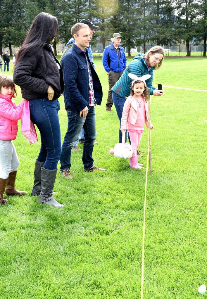 Lining up before the egg hunt, Maria and mom, Claudia Castle, and Sean Scott, his daughter Maia, and her grandparents Mark and Rosalie Aiken discuss egg-hunting strategies. Carol Ladwig/Staff Photo