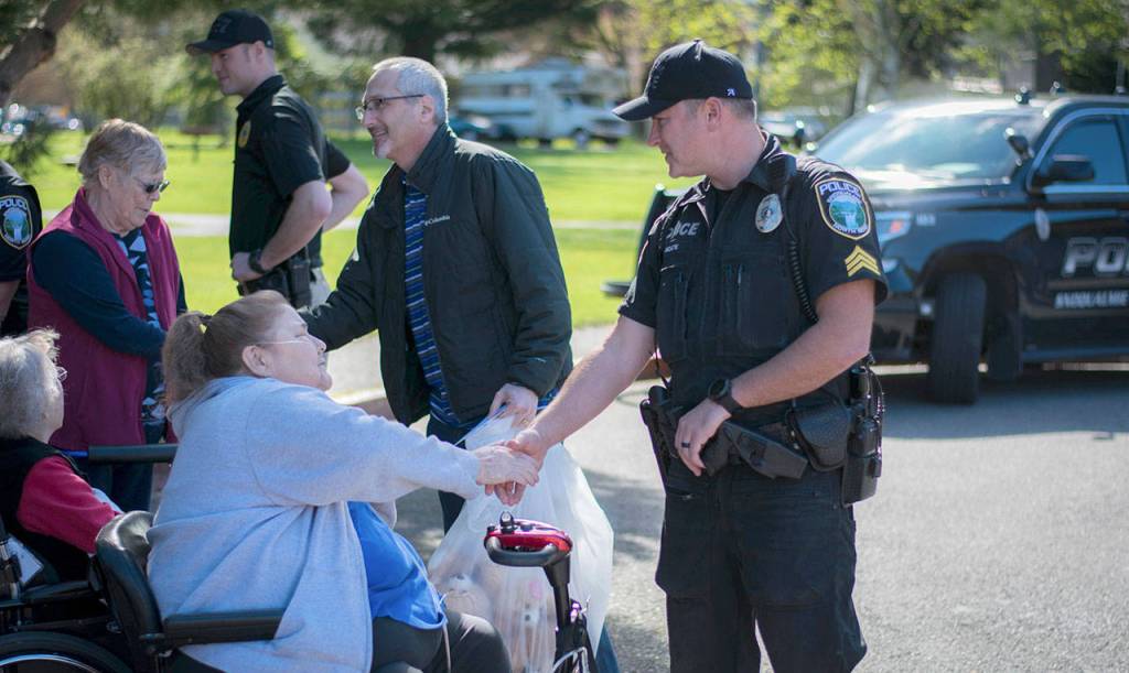 Officer Moate thanks one of the North Bend Regency Care residents for their donation. (Photo courtesy of NW Gypsy Photography)