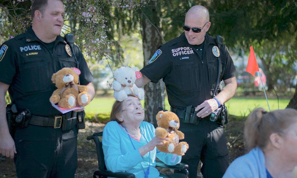 Officers and residents have a little fun with the teddy bears on Friday morning. (Photo courtesy of NW Gypsy Photography)