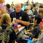 During a 2013 visit to North Bend Elementary School, students gather around to have lunch with Chief McCulley. Carol Ladwig/File Photo