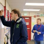 TLC student Nicholas writes a list of locations the class has traveled to in the past year.                                (Evan Pappas/Staff Photo)