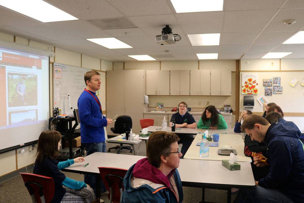 Para-educators sit with students of the Transition Learning Center as teacher Benjamin Bollinger explains the days lessons and activities.                                (Evan Pappas/Staff Photo)
