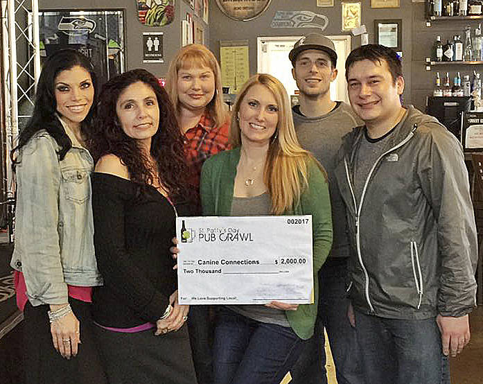 Courtesy Photo                                Posing with a donation check for Canine Connections are, from left: Alexandra French; Debbie Barrientes, owner of Infusion Bar and Grill; Kristine Haak of Imageworks Northwest; Jessica Self, Valley Young Professionals; Michael Hughes, owner of Dark Horse Ink; and Chris Barrientes, also of Infusion.