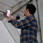 Luke Talbott gets a video call from his daughter during the introduction to the event. He answers the call and the audience laughs and waves to the camera.                                (Evan Pappas/Staff Photo)