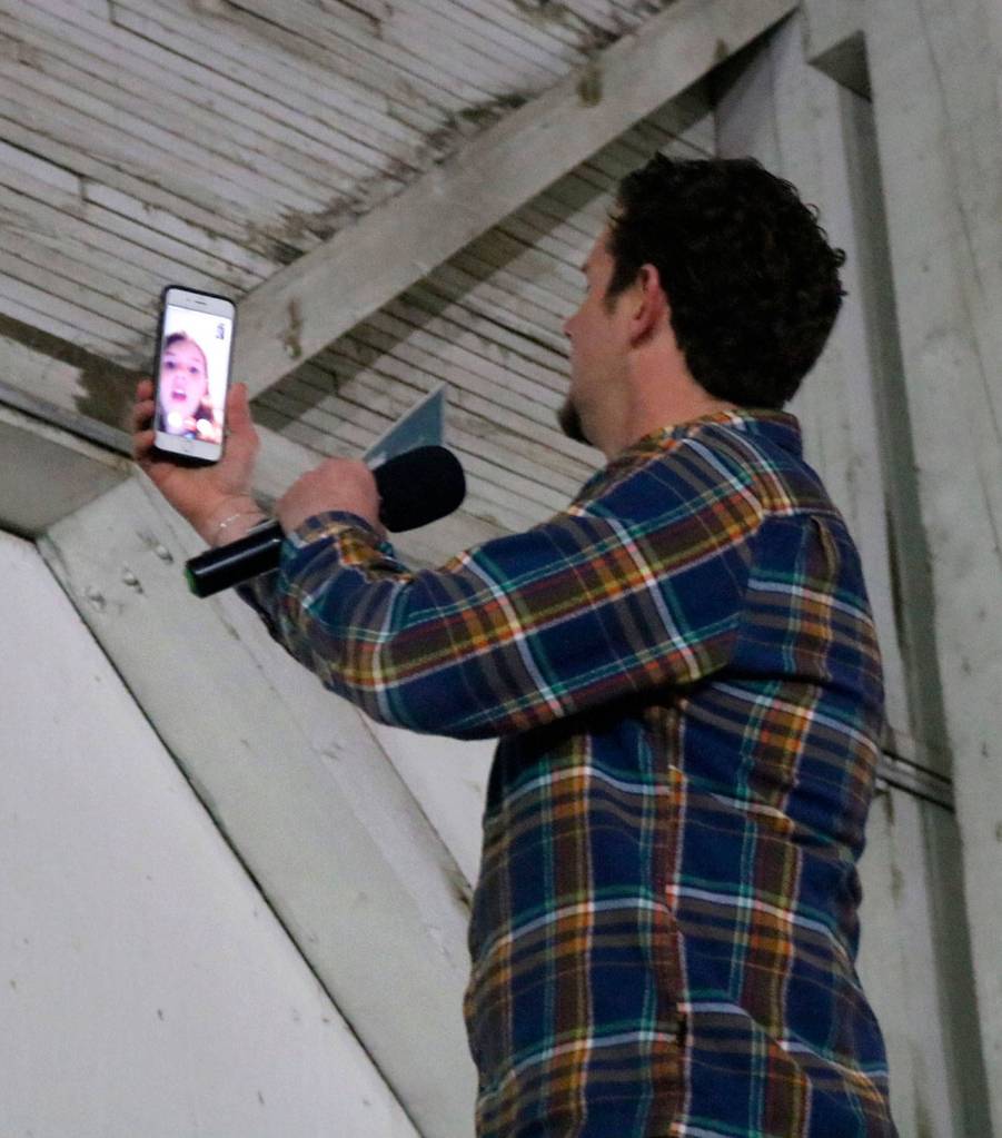 Luke Talbott gets a video call from his daughter during the introduction to the event. He answers the call and the audience laughs and waves to the camera.                                (Evan Pappas/Staff Photo)