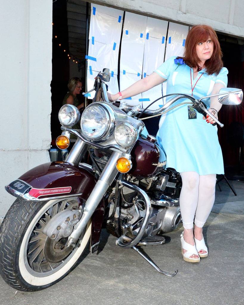 A Peaks fan poses for a photo with the original motorcycle used in the first season of Twin Peaks. It was brought to the premiere event by owner Arlie Becker.                                (Mary Miller Photo)