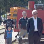 Landen Hearing, 14, plays with his brother, Graysen, 4, while accompanying their grandfather, North Bend Mayor Ken Hearing, to the celebration of three anniversaries for the Northwest Railway Museum. Also pictured is Snoqualmie City Councilman Bob Jeans, far right.                                Carol Ladwig/Staff Photo