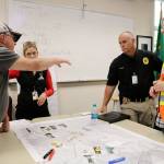 The North Bend team discuss disaster relief measures with Police Chief Perry Phipps during the earthquake drill.                                (Evan Pappas/Staff Photo)