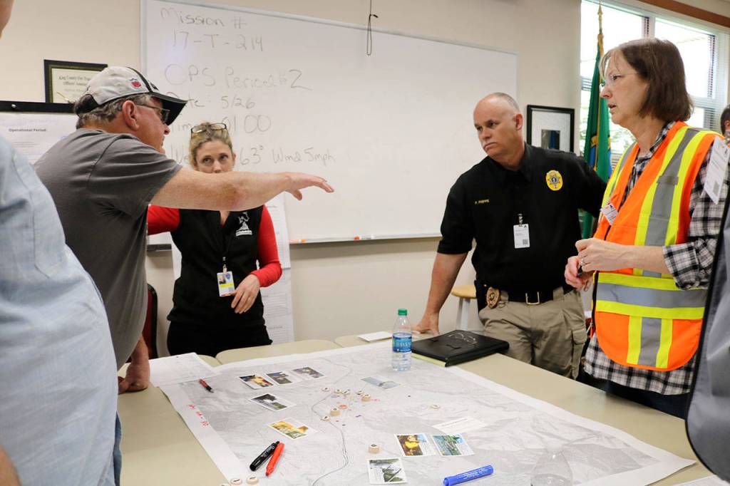 The North Bend team discuss disaster relief measures with Police Chief Perry Phipps during the earthquake drill.                                (Evan Pappas/Staff Photo)