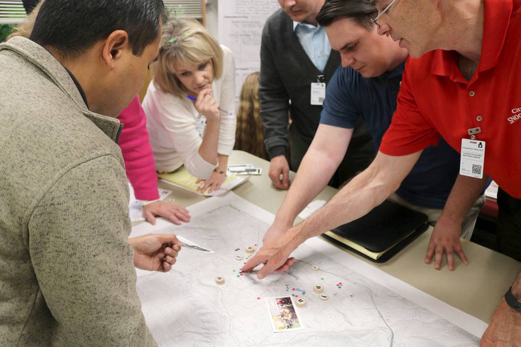 The Snoqualmie team examine the map of the city to plan their response to the mock earthquake.                                (Evan Pappas/Staff Photo)