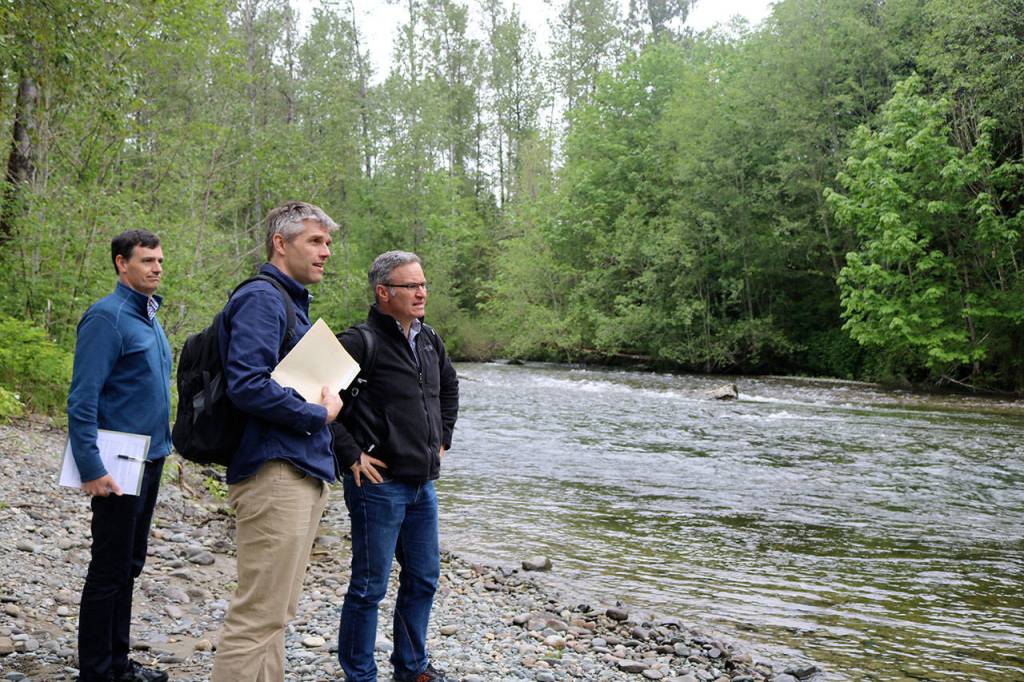 Perry Falcone, project coordinator for the Snoqualmie Watershed Forum, Chase Barton, supervising engineer for King County river and floodplain management, and Doug Williams, media relations coordinator for the King County Department of Natural Resources and Parks, stand at the shore of the tolt river on the San Souci property.                                (Evan Pappas/Staff Photo)
