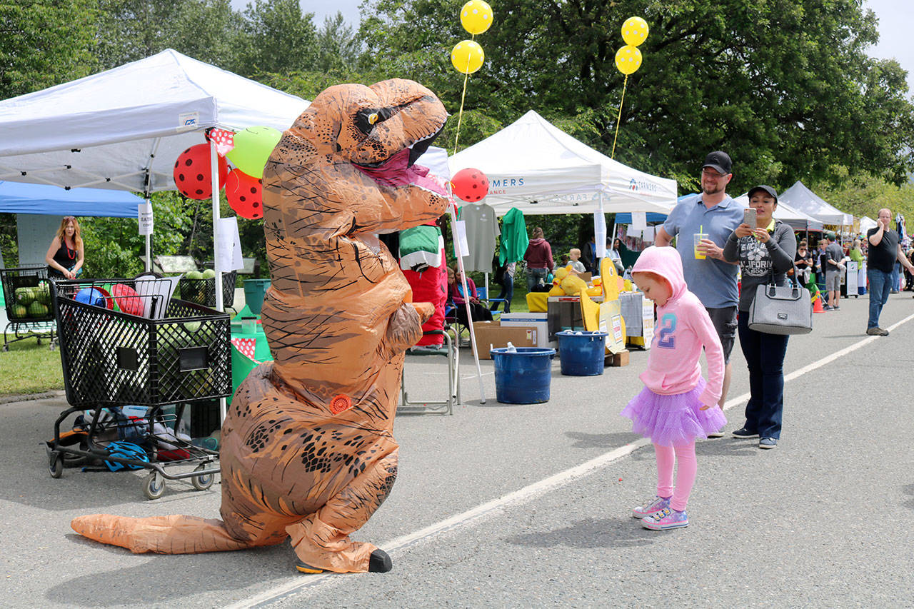 Krystal Keith dances with the watermelon-eating contest&rsquo;s dinosaur mascot while her parents take pictures. (Evan Pappas/Staff Photo)