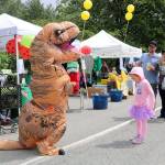 Krystal Keith dances with the watermelon-eating contest&rsquo;s dinosaur mascot while her parents take pictures. (Evan Pappas/Staff Photo)