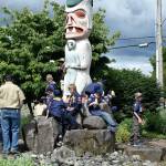 Boy Scouts from Troop 425 lounge on the Totem Garden totem pole as the floats line up for the Grand Parade Saturday.                                Carol Ladwig/Staff Photo