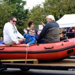 A young boy on the Fire District 27 rescue boat float waves to the camera.                                Carol Ladwig/Staff Photo