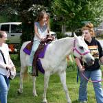 Ariana Zirkle, 8, enjoyed a pony ride Saturday at Fall City Day with her mother, Rachael. Next to go into the saddle was younger sister Emily.                                 (Carol Ladwig/Staff Photo)