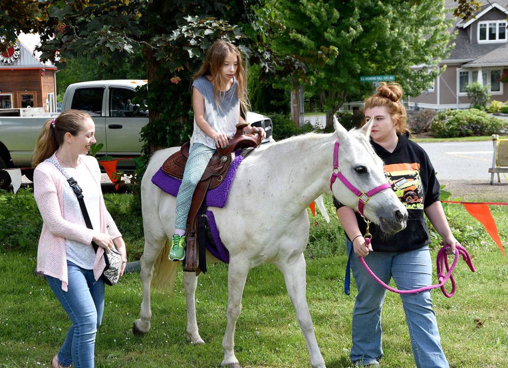 Ariana Zirkle, 8, enjoyed a pony ride Saturday at Fall City Day with her mother, Rachael. Next to go into the saddle was younger sister Emily.                                 (Carol Ladwig/Staff Photo)