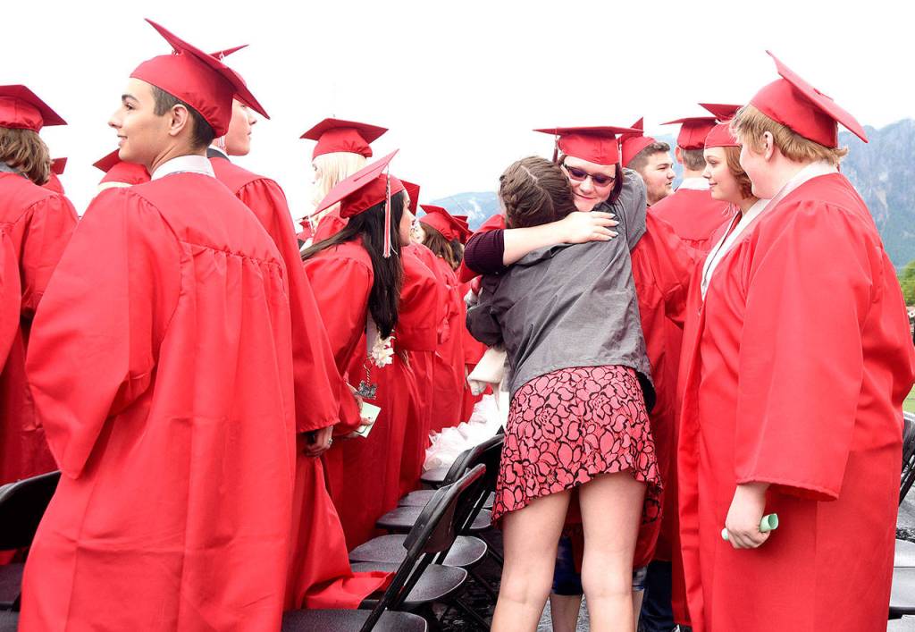 Breaking into the senior seating just before the ceremony begins, a Mount Si freshman gives one last hug to several of her senior friends.                                Carol Ladwig/Staff Photo