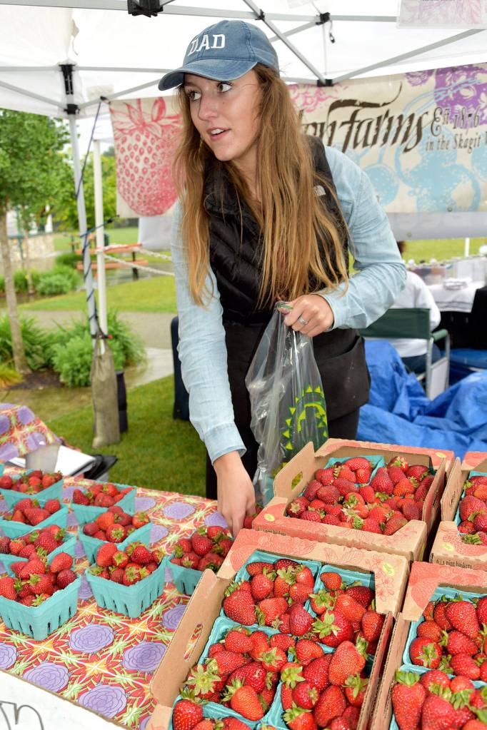 Carly Methner of Hayton Farms packages up some fresh strawberries for a customer.                                Carol Ladwig/Staff Photo