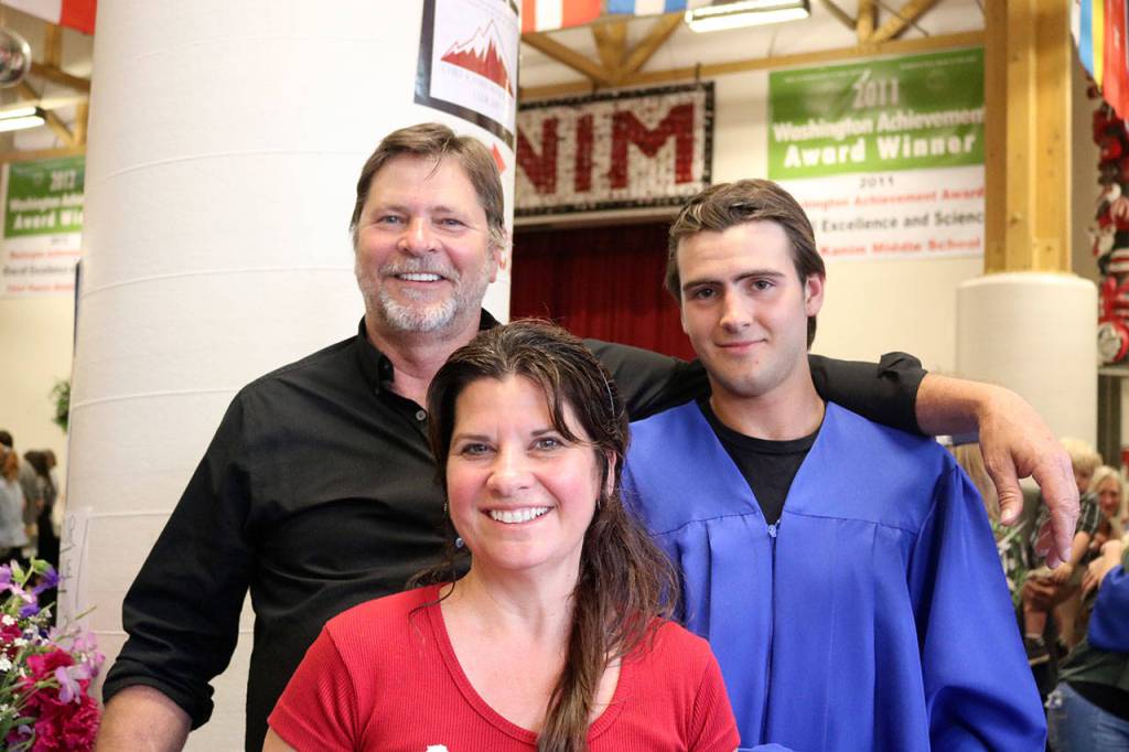 Cory Lewis, right, stands with his parents John and Debbie after graduating.                                (Evan Pappas/Staff Photo)