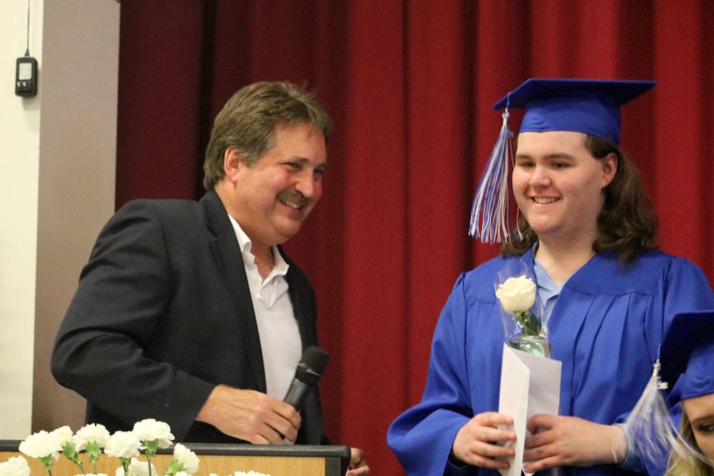 Snoqualmie Valley Rotary representative Steve Weaver presented Aaron Thompson with a $500 scholarship during the graduation ceremony.                                (Evan Pappas/Staff Photo)