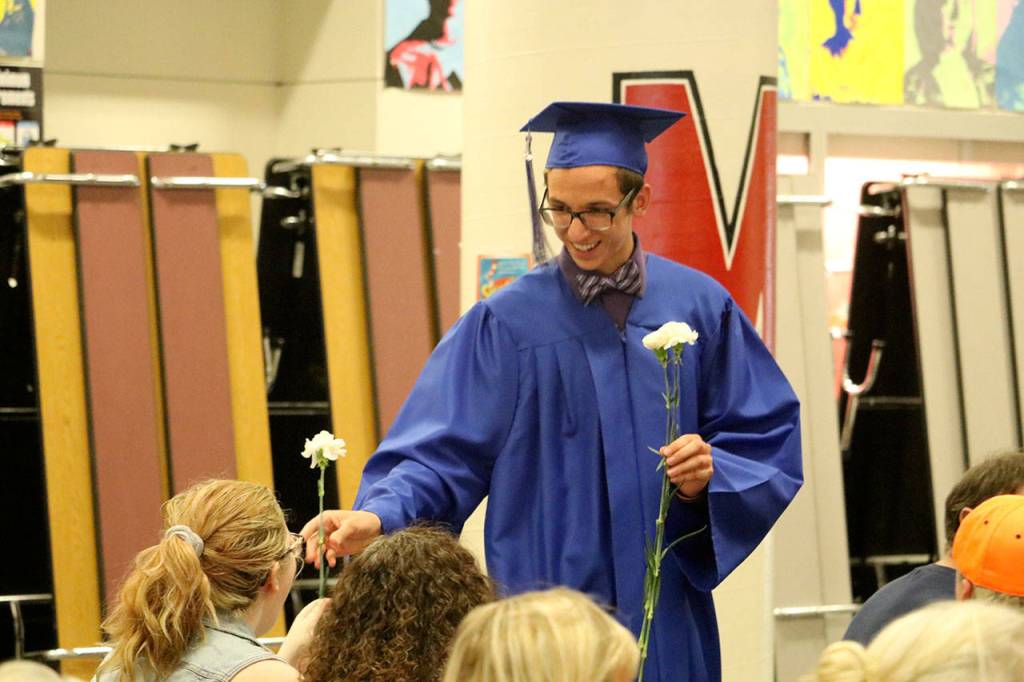 Two Rivers graduates handed flowers to their family and friends during the ceremony.                                (Evan Pappas/Staff Photo)