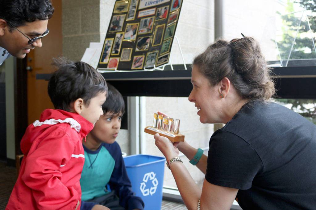 Mihit and Manas Mishra are shown a small exhibit detailing how baby salmon grow at Saturday&rsquo;s summer reading kick-off event at the Snoqualmie Library.                                (Evan Pappas/Staff Photo)