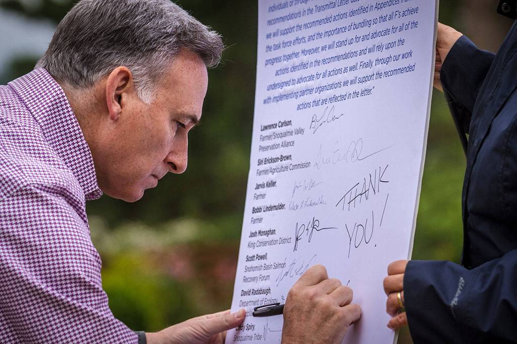 Dow Constantine writes &ldquo;Thank you!&rdquo; on the list of recommendations from the Fish, Farm, Flood advisory committee.                                Photo courtesy of Eli Brownell