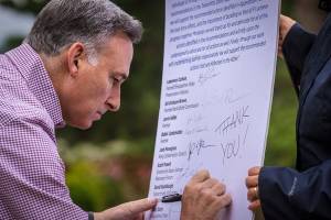 Dow Constantine writes &ldquo;Thank you!&rdquo; on the list of recommendations from the Fish, Farm, Flood advisory committee.                                Photo courtesy of Eli Brownell