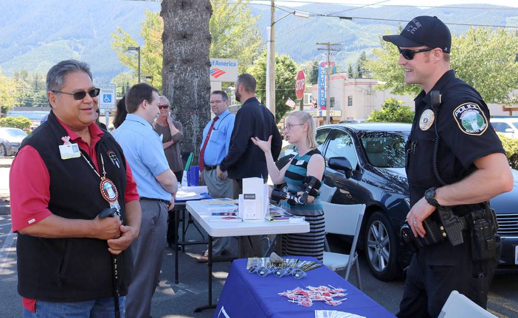 Snoqualmie Tribe Chief Andy De Los Angeles speaks with Officer Chad Ridout at the Snoqualmie Police Department booth at last week&rsquo;s community job fair.                                (Evan Pappas/Staff Photo)