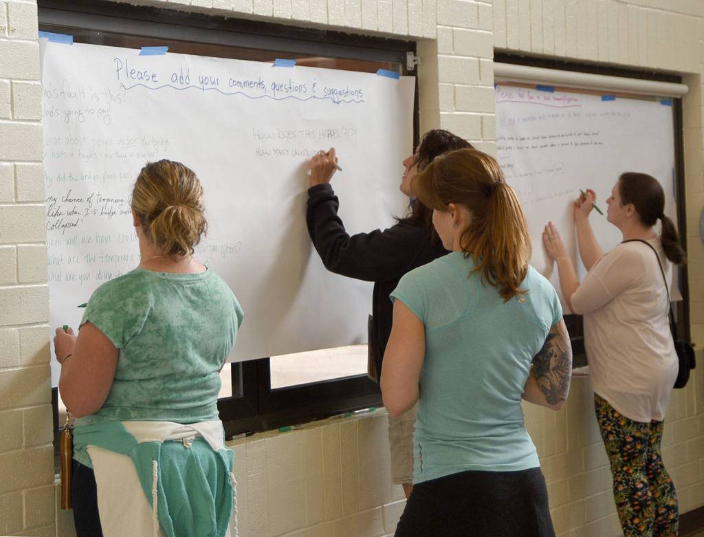 Residents write comments on provided feedback lists at the open house Wednesday on the Tolt Hill Bridge closure.                                Carol Ladwig/Staff Photo