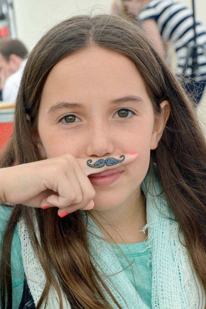 Ava Willard makes the most of her mustache henna tattoo at the 2016 Block Party.                                (Photo by Mary Miller)