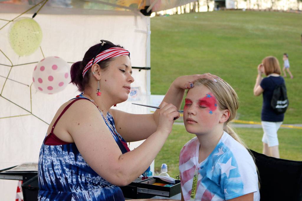 Chloe Fredell gets her face painted at the Party Art by Robin booth. (Evan Pappas/Staff Photo)