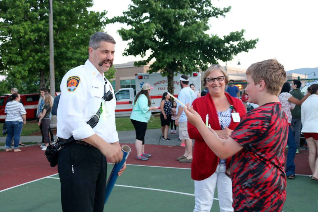Snoqualmie Fire Chief Mark Correira, along with other firefighters, handed out glowsticks to kids at the Red White and Boom event. (Evan Pappas/Staff Photo)