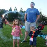 Kyla Hollan draws a circle in the air with a sparkler as her dad Jeff cheers her on. (Evan Pappas/Staff Photo)