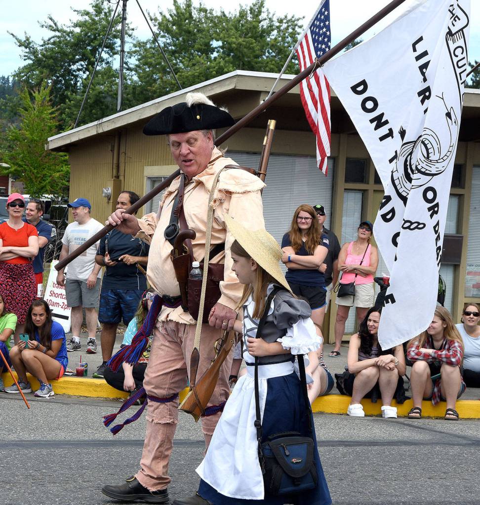 Mike Wegner and daughter, representing the Culpeper Minutemen, march in the Carnation parade. (Carol Ladwig Staff Photo)